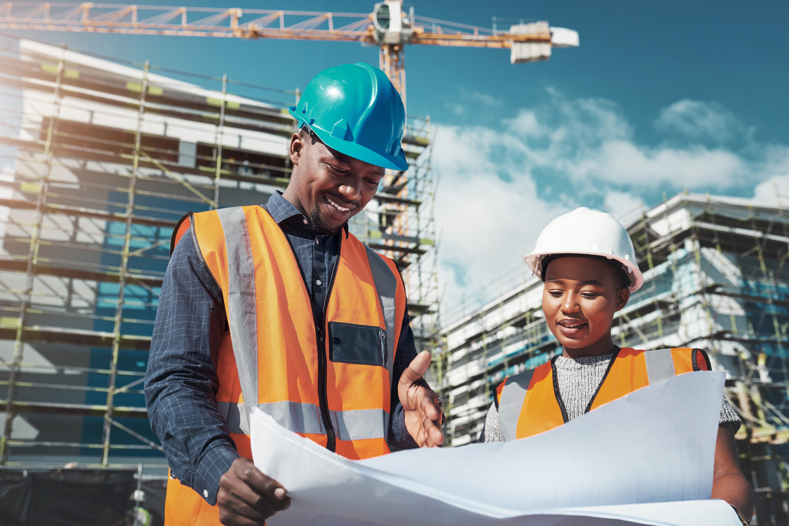 Shot of a young man and woman going over building plans at a construction site.